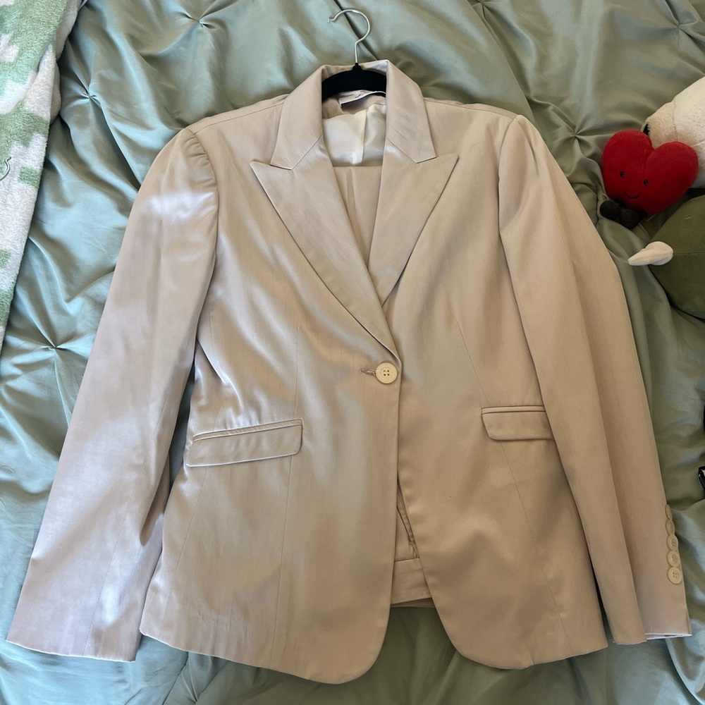 cream blazer with subtle striped designs and matching pants